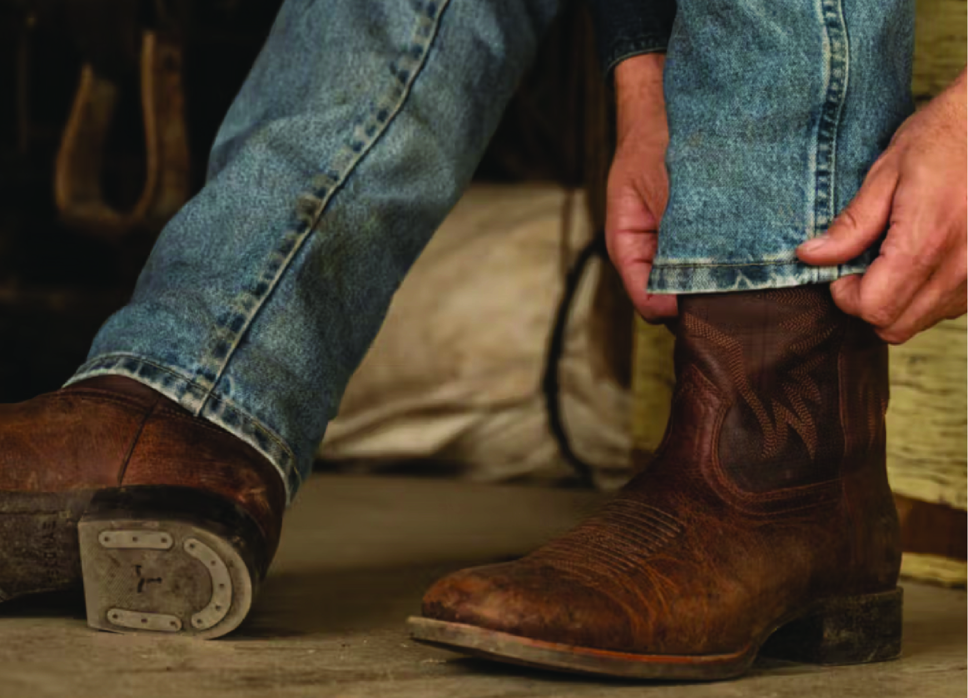 Person pulling their jeans over their cowboy boots